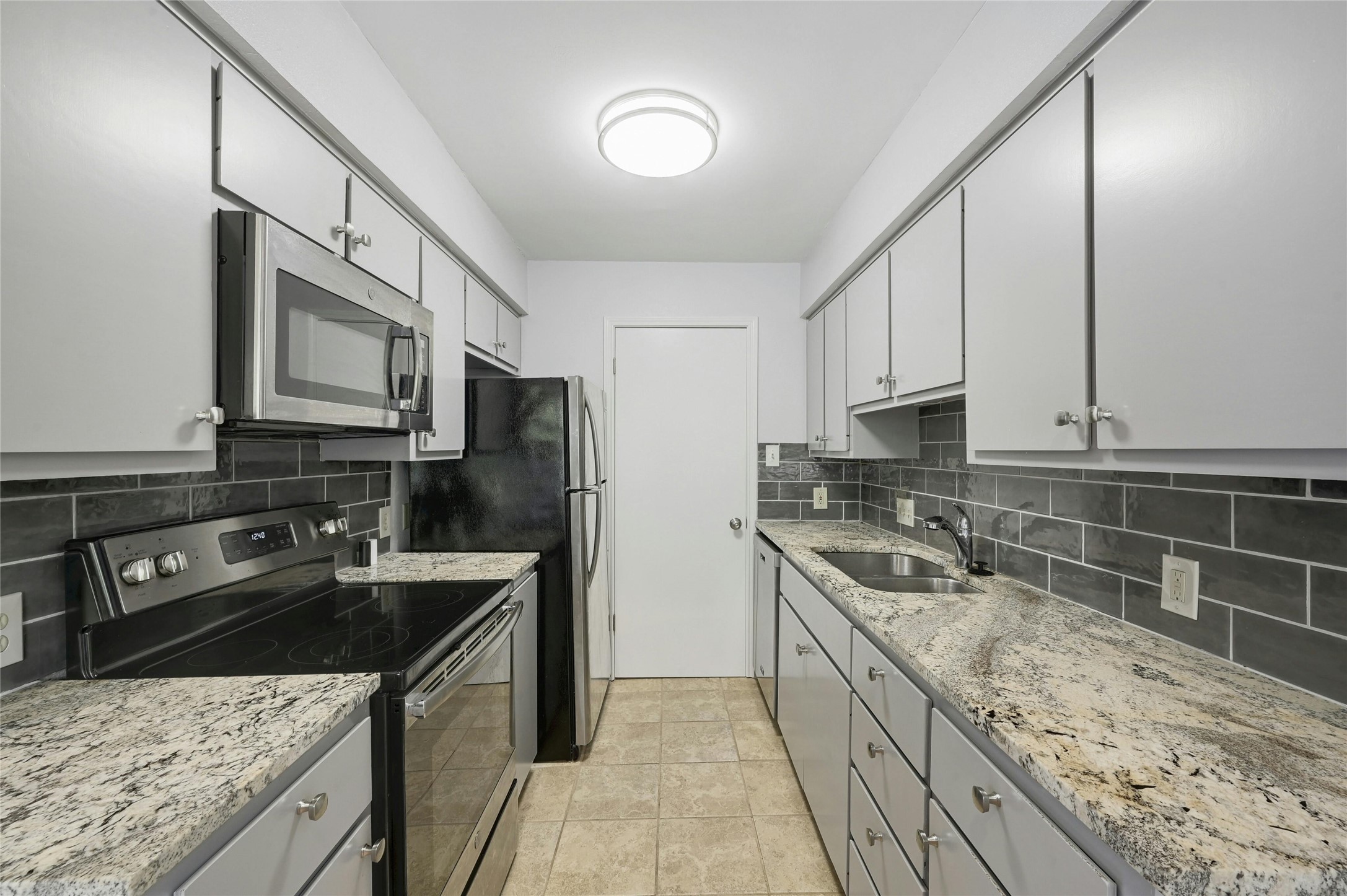 9226 Jollyville Road, Unit 221 Austin, TX 78759 - Photo 8 of 20 A well-appointed kitchen features stainless steel appliances, granite countertops, and modern subway tile.