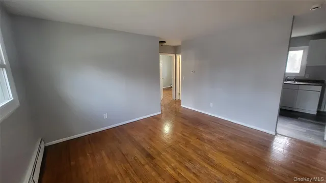 an empty room with wooden floor and entrance