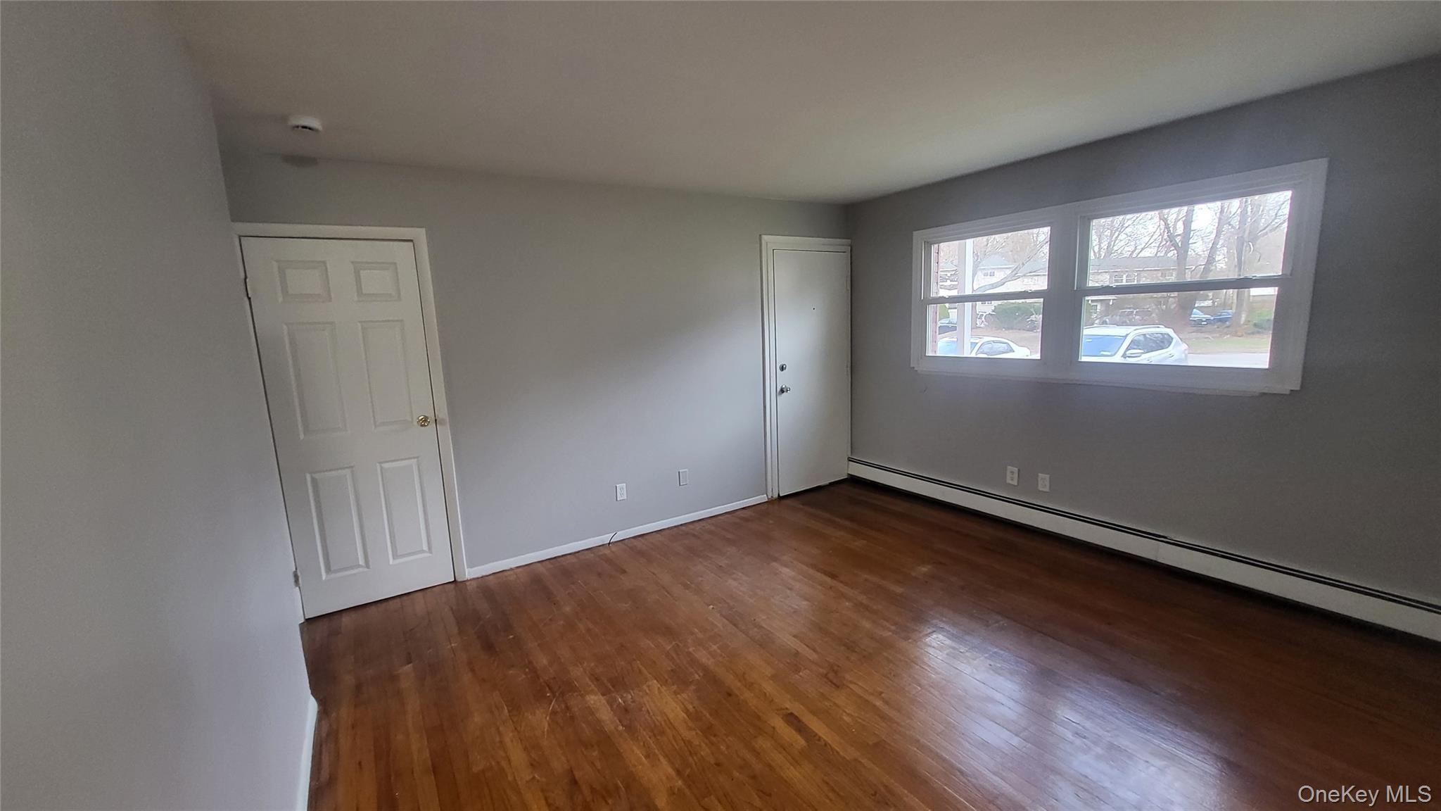 40 Haviland Road, Unit A7 Poughkeepsie, NY 12601 - Photo 5 of 12 an empty room with wooden floor and windows