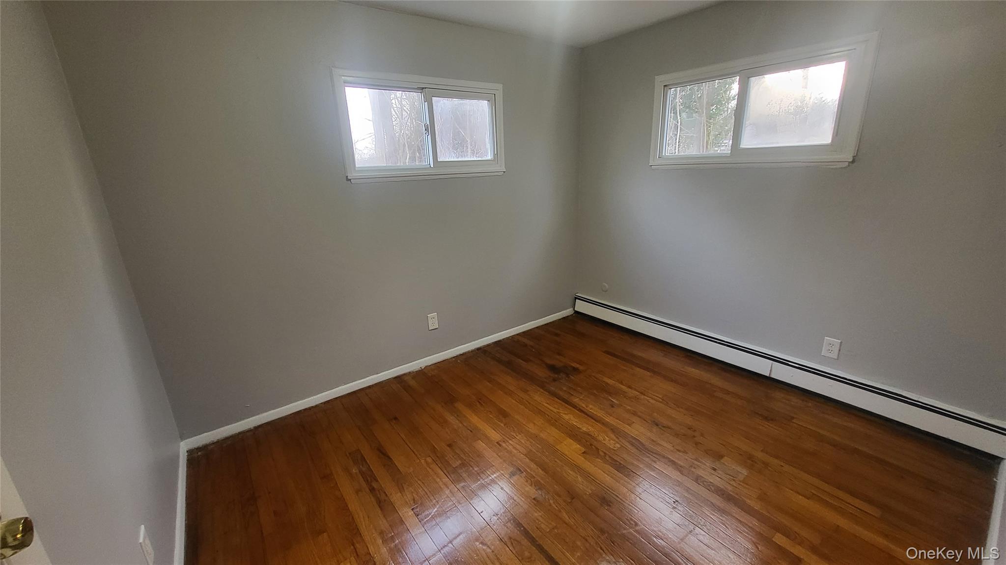 40 Haviland Road, Unit A7 Poughkeepsie, NY 12601 - Photo 10 of 12 an empty room with wooden floor and windows