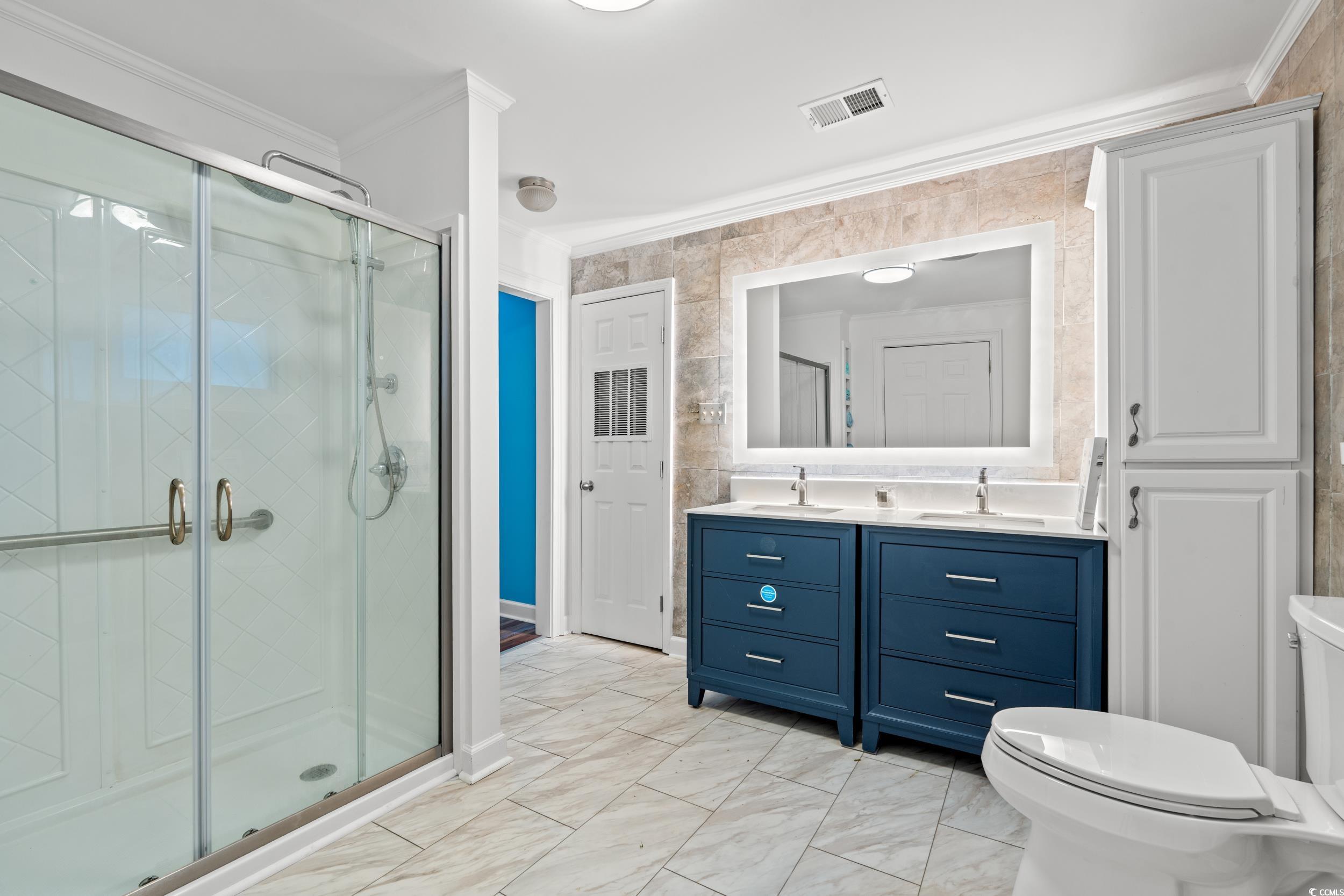902 Palm Street Georgetown, SC 29440 - Photo 17 of 38 Bathroom featuring crown molding, double vanity, and a stall shower