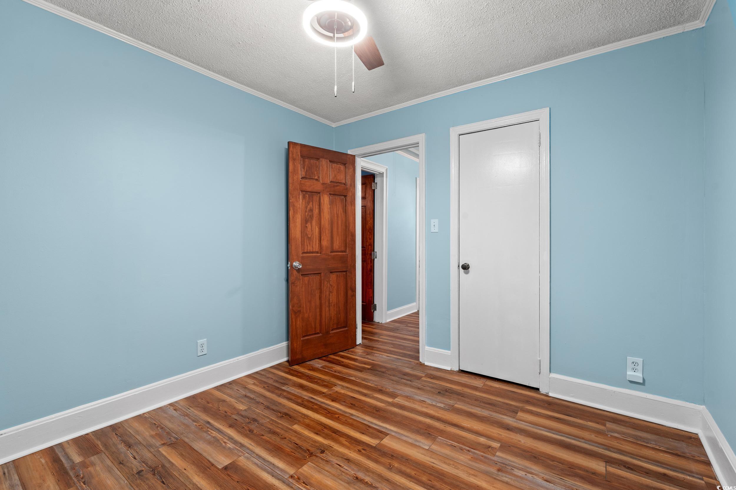 902 Palm Street Georgetown, SC 29440 - Photo 21 of 38 Unfurnished bedroom featuring ornamental molding, a textured ceiling, dark wood-style floors, and ceiling fan