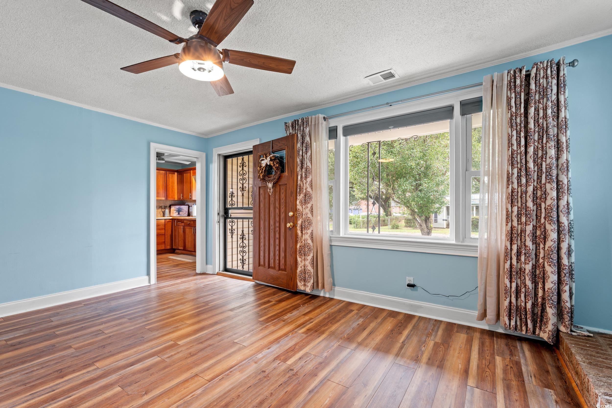 902 Palm Street Georgetown, SC 29440 - Photo 6 of 38 Unfurnished bedroom featuring ornamental molding, wood finished floors, a textured ceiling, and ceiling fan
