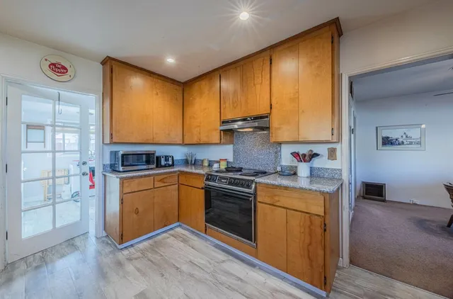 a kitchen with stainless steel appliances granite countertop wooden cabinets and a stove top oven