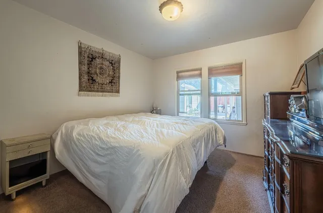 a bedroom with a bed and a flat screen tv