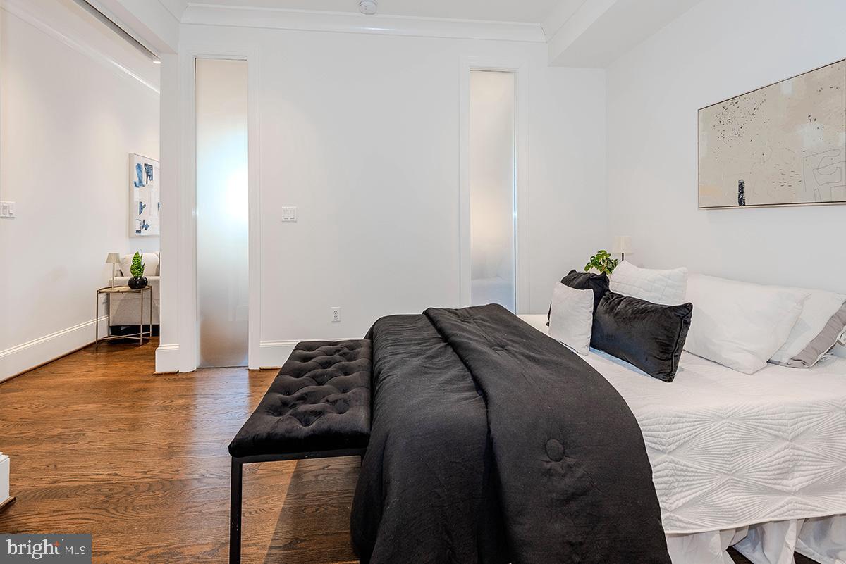 418 7th Street Southeast, Unit 302 Washington, DC 20003 - Photo 13 of 35 a bedroom with a bed and wooden floor