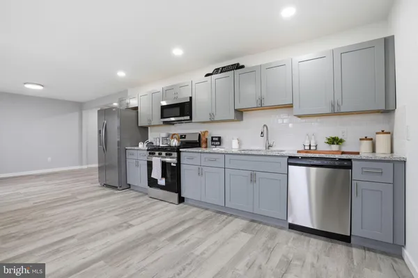 a kitchen with granite countertop a refrigerator stove top oven and sink