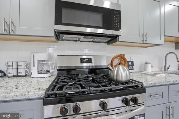 a stove top oven sitting inside of a kitchen