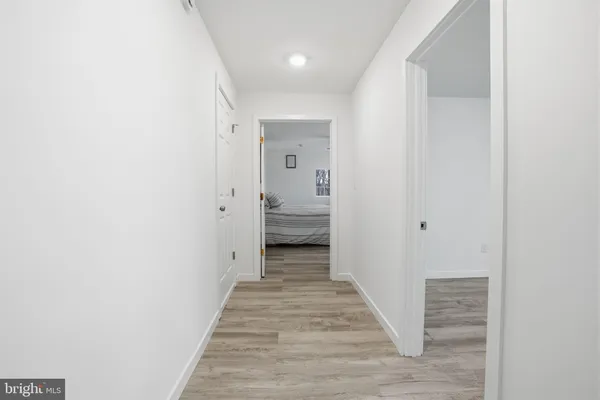 a view of a hallway with wooden floor and closet