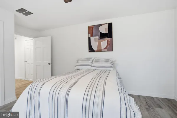 a bedroom with a bed and painting on the wall