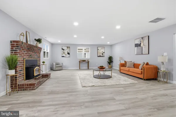 a living room with furniture a fireplace and a wooden floor