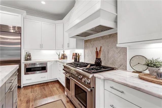 a kitchen with kitchen island a counter top space a sink stainless steel appliances and cabinets
