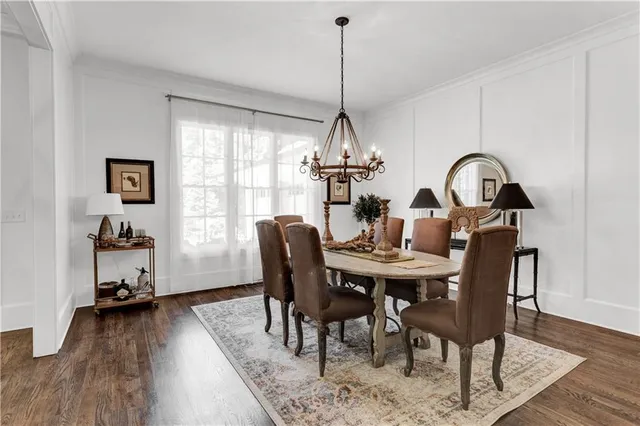 a view of a dining room and livingroom with furniture wooden floor a chandelier