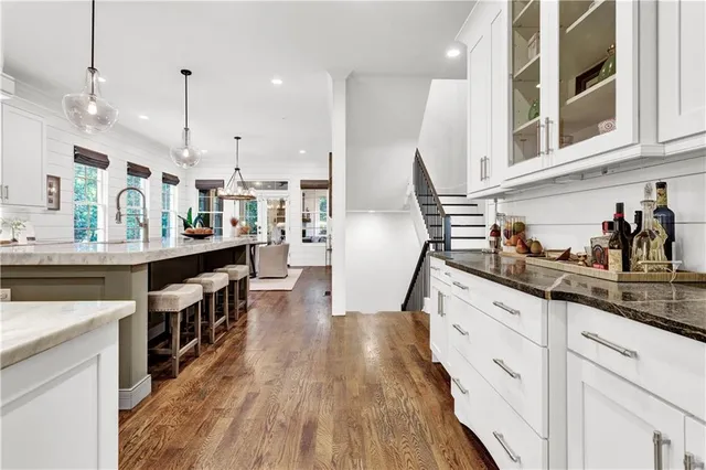 a kitchen with stainless steel appliances granite countertop a lot of counter space and wooden floors