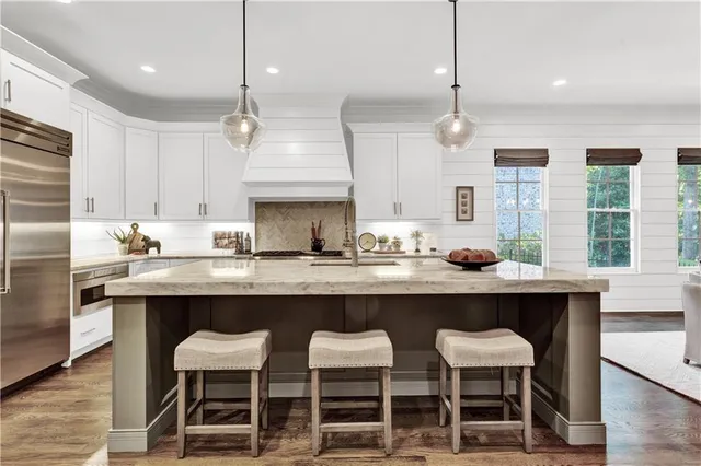 a living room with furniture a chandelier and large windows
