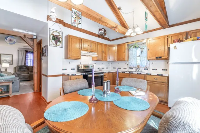 a dining room with furniture a large window and stainless steel appliances