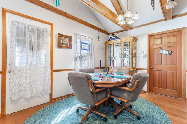 a dining room with furniture a chandelier and wooden floor