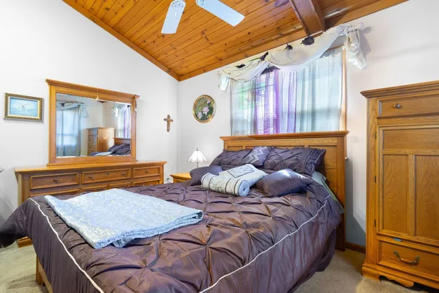 a bedroom with a bed and a large mirror on the dresser