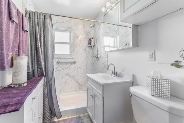 a bathroom with a sink a toilet and shower