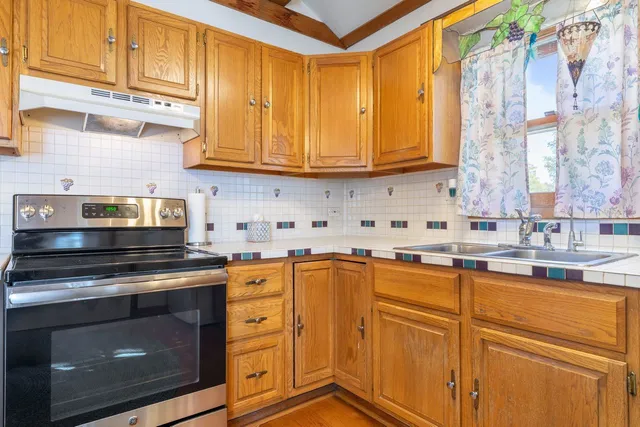 a kitchen with stainless steel appliances granite countertop a sink a stove and cabinets