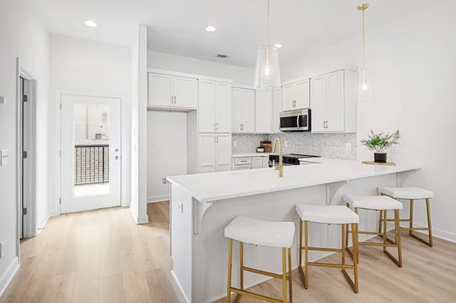 a kitchen with kitchen island white cabinets and stainless steel appliances