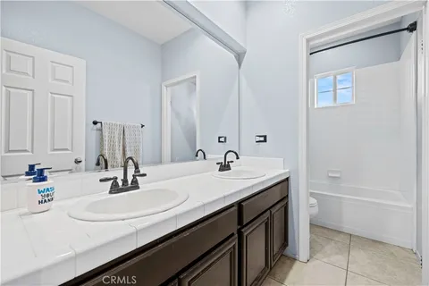 a bathroom with a sink double vanity granite tub and a mirror