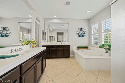 a bathroom with a sink a vanity a tub and a mirror