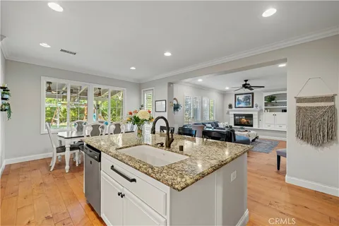 a kitchen with granite countertop kitchen island stainless steel appliances a sink and a living room