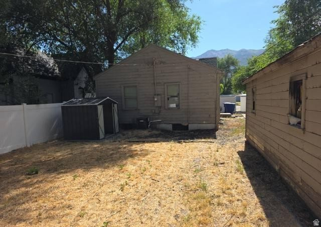 3161 Adams Avenue Ogden, UT 84403 - Photo 16 of 17 Expansive backyard with a composite storage shed, white vinyl fencing, and mature trees
