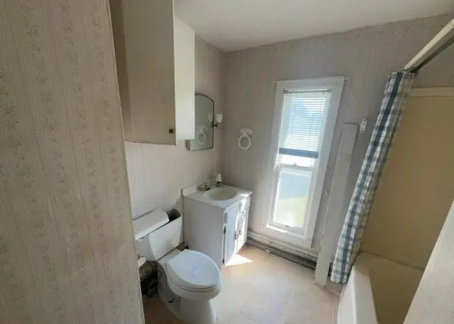 a bathroom with a toilet and a shower
