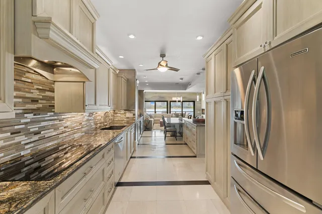 a kitchen with stainless steel appliances granite countertop a refrigerator and a stove