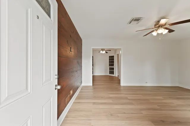 a view of a hallway with wooden floor and staircase
