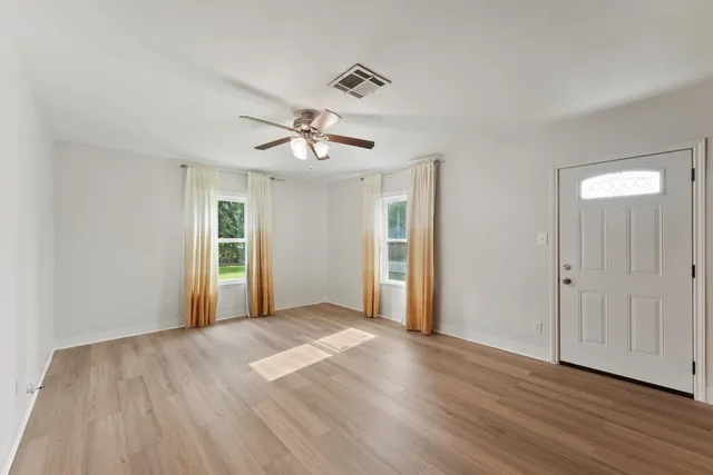 a view of an empty room with wooden floor