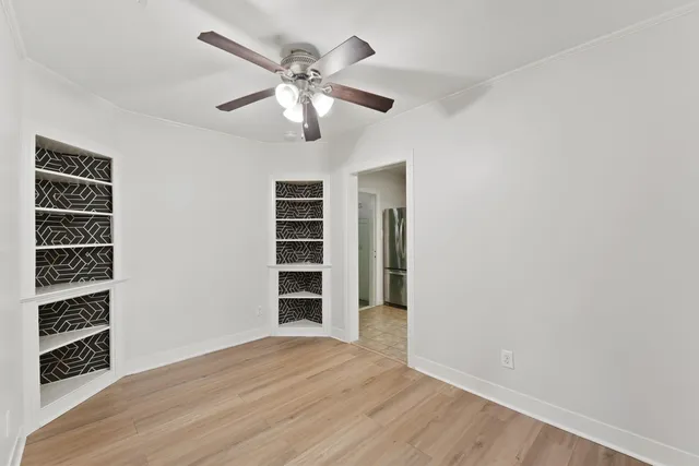 a view of empty room with wooden floor and window