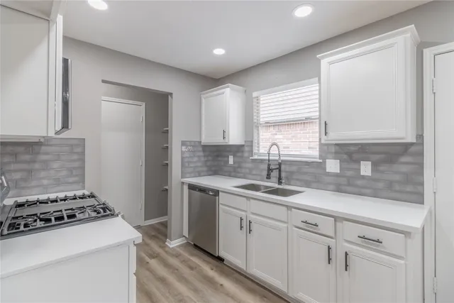 a kitchen with a stove a sink and a refrigerator