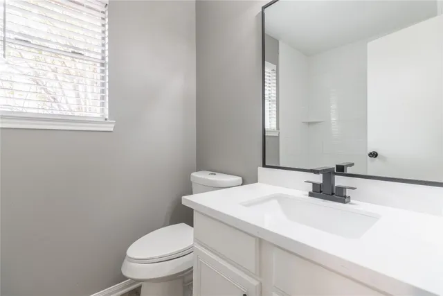 a bathroom with a sink toilet and a mirror