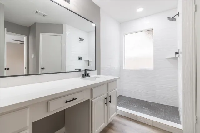 a bathroom with a sink and a mirror with bathtub