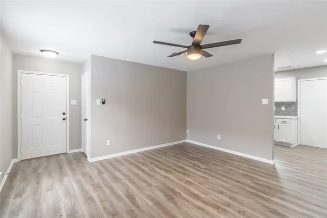a view of an empty room with wooden floor