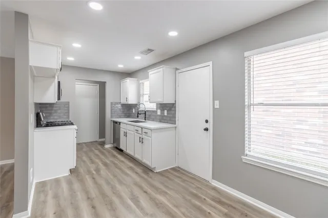 a kitchen with white cabinets and white appliances