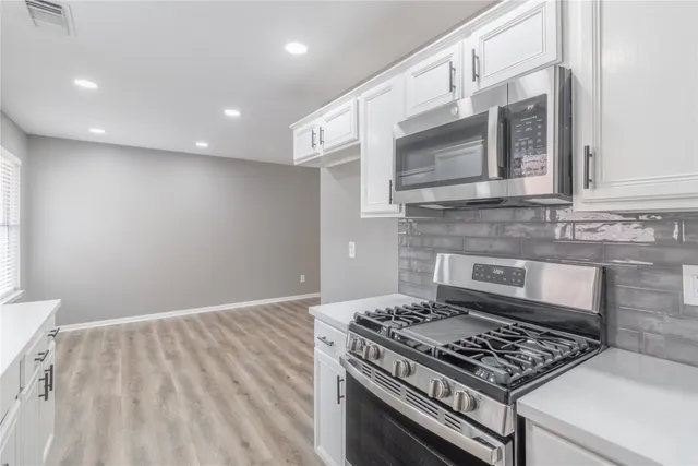 a stove top oven sitting inside of a kitchen