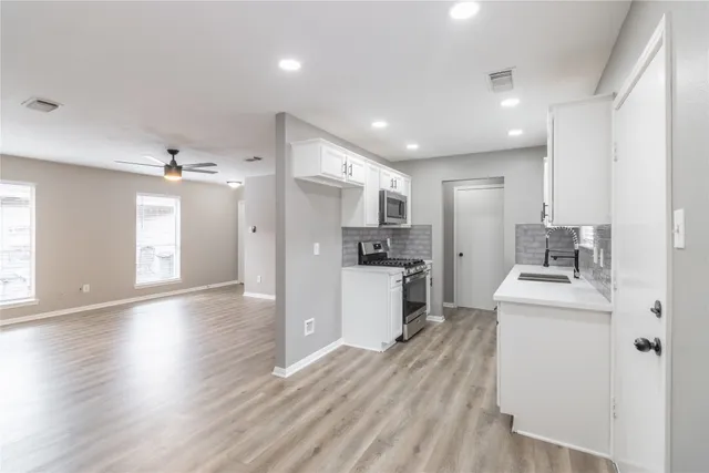 a kitchen with stainless steel appliances a refrigerator sink and cabinets