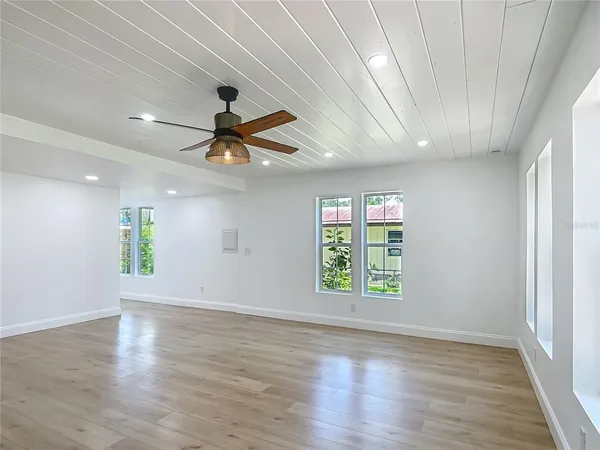 a view of wooden floor and a chandelier fan in a room