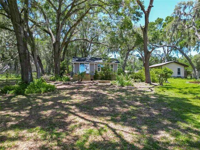 a view of a house with backyard and sitting area