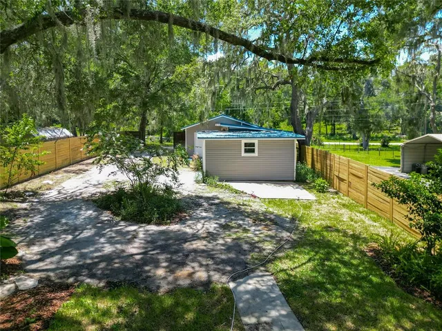 a view of a house with backyard and trees