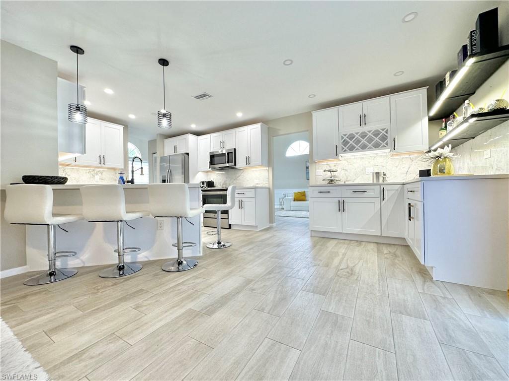 3639 Kent Drive Naples, FL 34112 - Photo 13 of 47 a large kitchen with lots of counter space and appliances