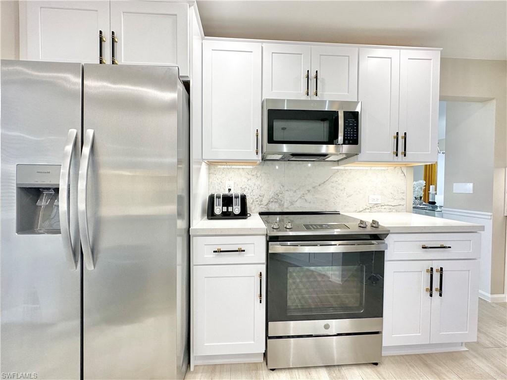 3639 Kent Drive Naples, FL 34112 - Photo 18 of 39 a kitchen with a stove and a microwave