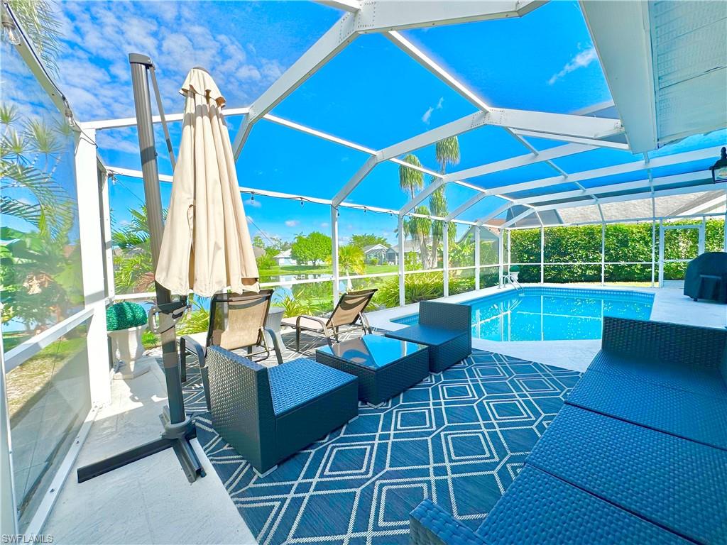 3639 Kent Drive Naples, FL 34112 - Photo 43 of 47 a view of an outdoor sitting area with furniture and umbrella