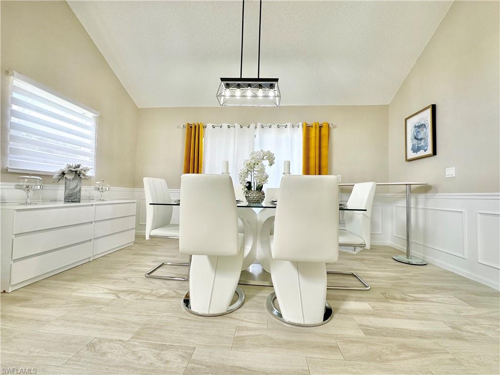 3639 Kent Drive Naples, FL 34112 - Photo 10 of 47 a dining room with wooden floor a chandelier a glass table and windows