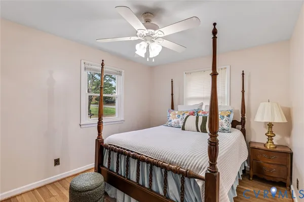 a bedroom with a bed a chandelier and a window