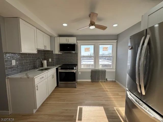 a kitchen with granite countertop a refrigerator stove and sink